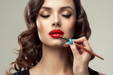 Makeup Artist Applying Red Lipstick — Beautician in Coffs Harbour, NSW