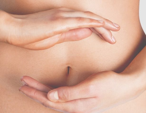 Woman Holding Hands Near Stomach — Beautician in Coffs Harbour, NSW