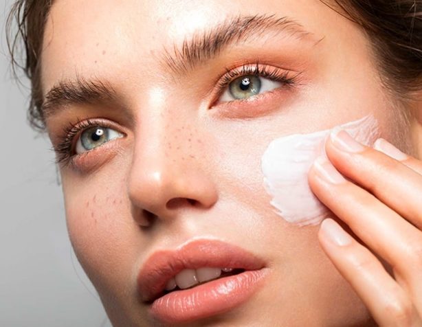 Woman Applying Lotion on Face — Beautician in Coffs Harbour, NSW